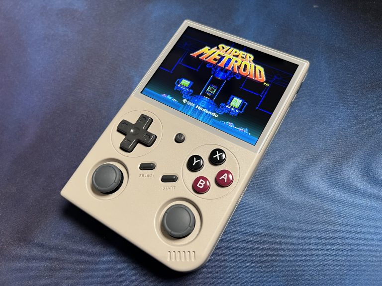 Der BATLEXP G350 liegt auf Stoffuntergrund, Display zeigt die Titelgrafik von Super Metroid in kräftigen Blautönen.